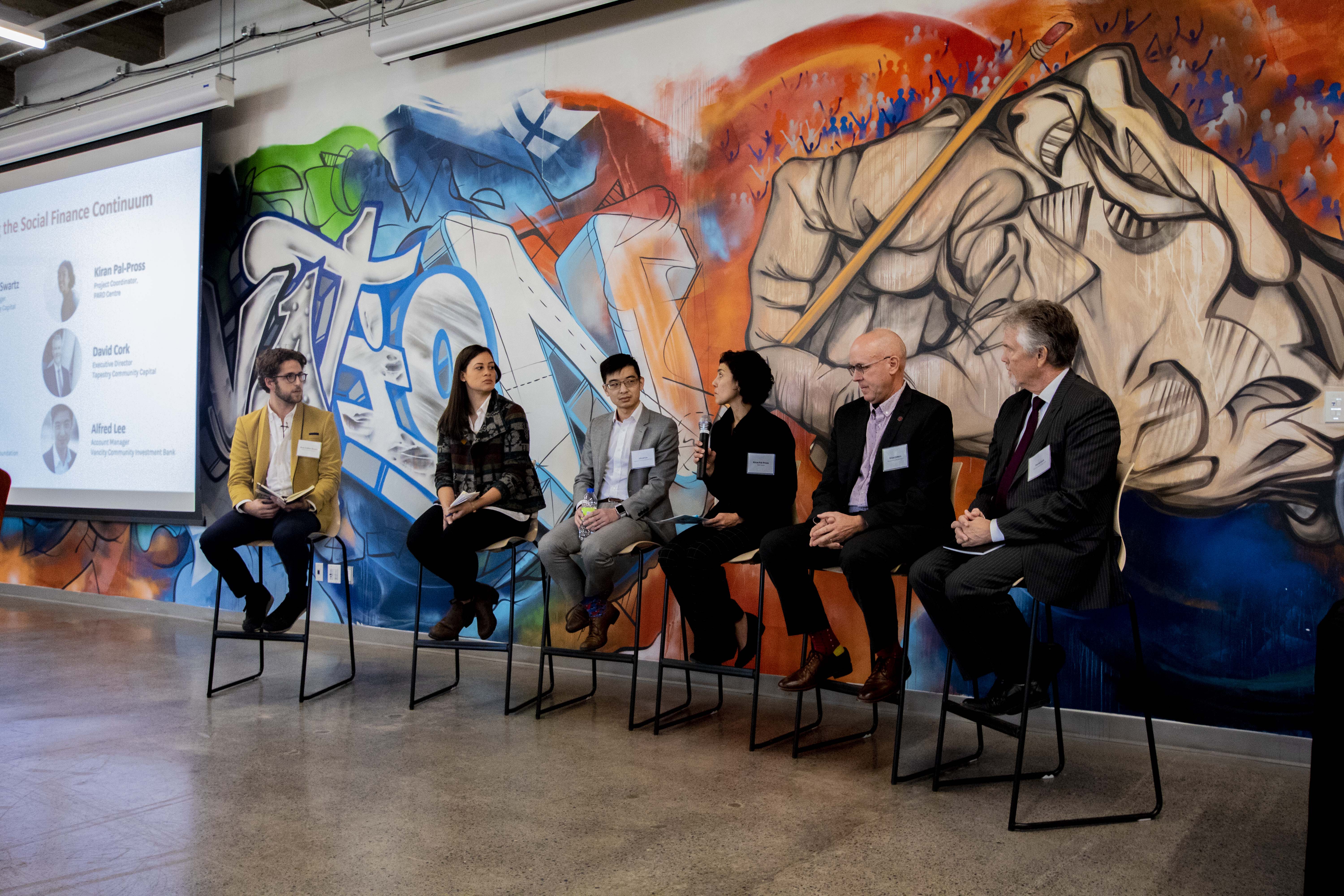 A panel of speakers sitting on stools