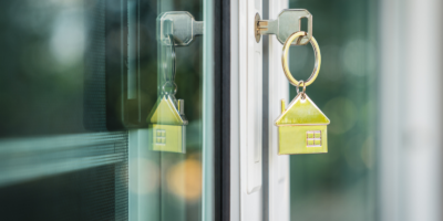 A key with a house-shaped keychain in a door lock, reflecting the Housing Supply Challenge ahead.