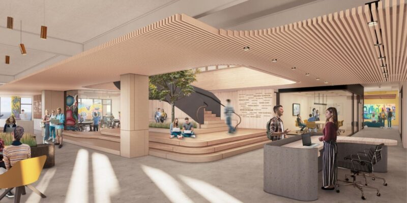 Un bureau moderne et ouvert où les employés travaillent, discutent et se détendent près d'un escalier en bois et d'un arbre d'intérieur KCS situé au centre de la pièce.