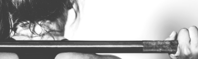 A woman lifting a weight rack on her back