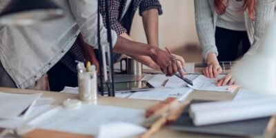 Two people collaborate over documents, building a strong community bond in a well-lit office workspace.